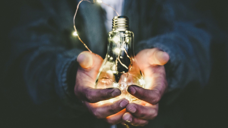 Person holding lightbulb in their hands